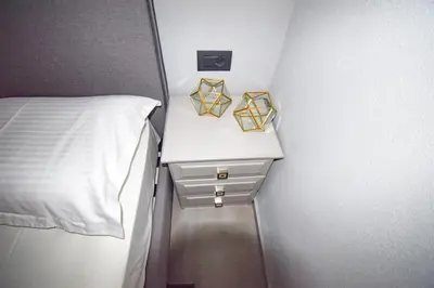 a small bedroom with a bed and a white bedside table at Vasiliki Venetian suites in Chania Town