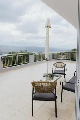 a patio with two chairs and a table on a balcony at AITHRA seaside in Arónion