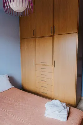 a bedroom with a bed and wooden cabinets at AITHRA seaside in Arónion