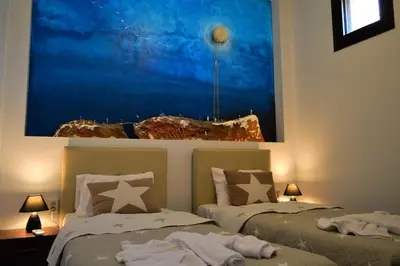 two beds in a room with a picture on the wall at Villa Marie Homeleader in Delimanolianá