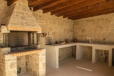 a stone kitchen with a stove and a stone wall at Villa Marie Homeleader in Delimanolianá