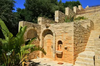 a brick building with an archway in a yard at Villa Marie Homeleader in Delimanolianá