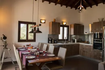 a kitchen with a table with chairs and a camera at Villa Marie Homeleader in Delimanolianá