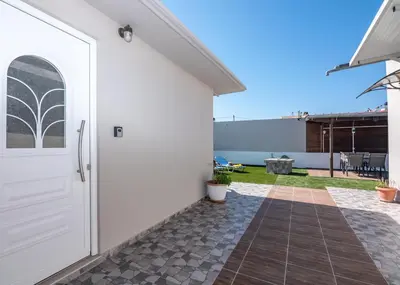 a white door on the side of a house with a patio at Margie's Apartments in Kissamos