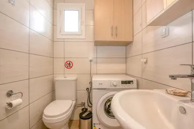 a small bathroom with a toilet and a sink at Margie's Apartments in Kissamos