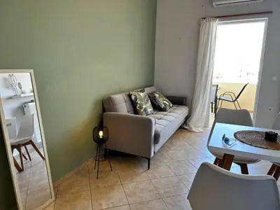 a living room with a couch and a table and a mirror at Son of the Beach Apartment - 20sec walk to beach in Chania Town