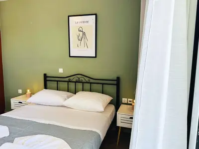 a bedroom with two beds and a picture on the wall at Son of the Beach Apartment - 20sec walk to beach in Chania Town