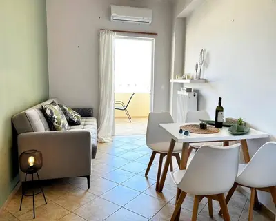 a living room with a couch and a table and chairs at Son of the Beach Apartment - 20sec walk to beach in Chania Town