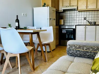 a kitchen with a table and chairs and a refrigerator at Son of the Beach Apartment - 20sec walk to beach in Chania Town