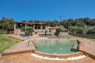 a swimming pool in a yard with a house at Villa Dimmare by PosarelliVillas in Kissamos