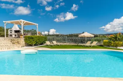 a pool with chairs and a gazebo at Villa Faye by PosarelliVillas in Metókhion