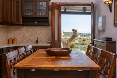 a kitchen with a wooden table with a bowl on it at Villa Faye by PosarelliVillas in Metókhion