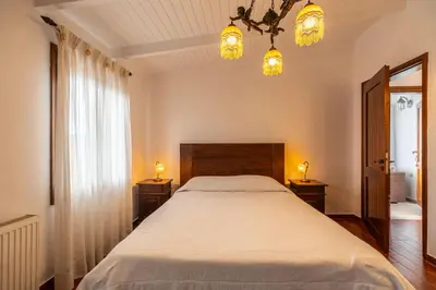 a bedroom with a bed with two night stands and two lights at Villa Faye by PosarelliVillas in Metókhion
