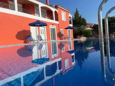 a swimming pool in front of a building at Dans une villa avec piscine privée, calme, proche des plages, vues mer et montagnes in Tsivarás