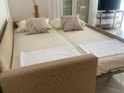 a couch with two pillows on it in a room at Dans une villa avec piscine privée, calme, proche des plages, vues mer et montagnes in Tsivarás