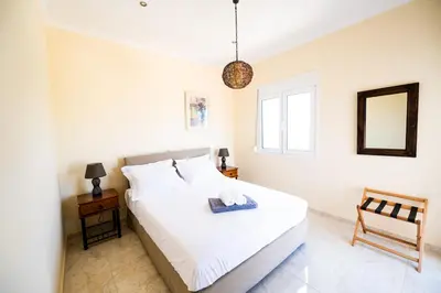 a bedroom with a bed with a mirror and a chair at Villa Astrea in Sinoikismós Mamounianá