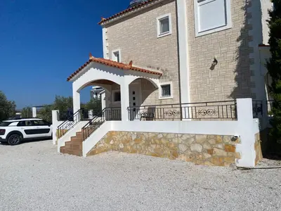 a house with a stone staircase in front of a building at Villa Astrea in Sinoikismós Mamounianá