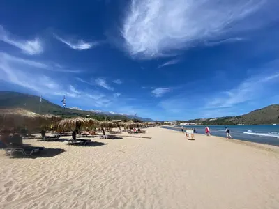 a beach with chairs and umbrellas and the ocean at Villa Astrea in Sinoikismós Mamounianá