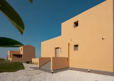 a building in the desert with a blue sky at Giannoulis Ele Villas in Skoutelónas