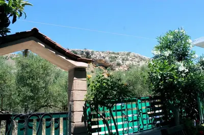 a green gate with a mountain in the background at Village Villa Marika Drapanias in Drapaniás