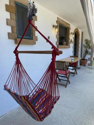 a red hammock hanging in a room with a table at Village Villa Marika Drapanias in Drapaniás