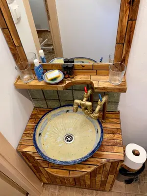 a bathroom with a sink with a wooden counter top at Village Villa Marika Drapanias in Drapaniás