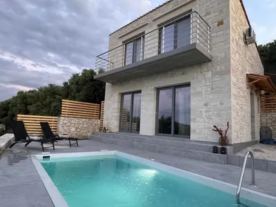 a house with a swimming pool in front of a house at Villa Maria in Stalos