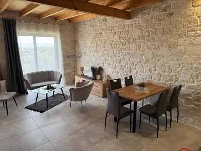 a living room with a wooden table and chairs at Villa Maria in Stalos