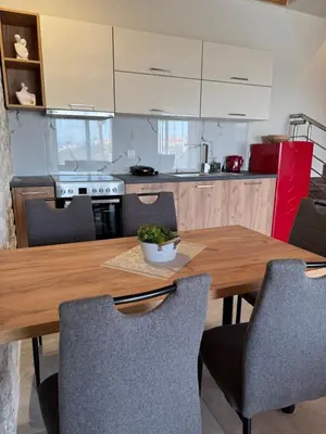 a kitchen with a wooden table and chairs at Villa Maria in Stalos
