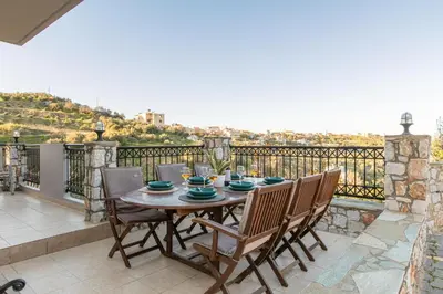 a table and chairs on a balcony with a view at Dimosthenis by Vintage Travel in Stalos