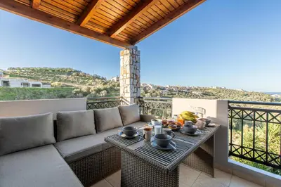 a patio with a couch and a table with fruit on it at Dimosthenis by Vintage Travel in Stalos
