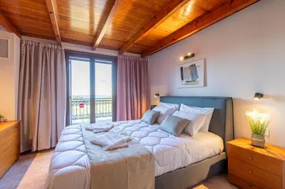 a bedroom with a large bed with a large window at Dimosthenis by Vintage Travel in Stalos