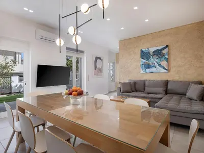 a dining room and living room with a dining table at Amelia Luxury Living Mantaka in Chania Town