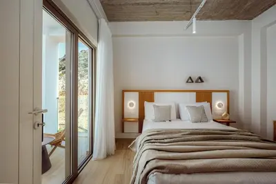 a bedroom with a large bed and a large window at Ethereal White Villas in Gramvousá