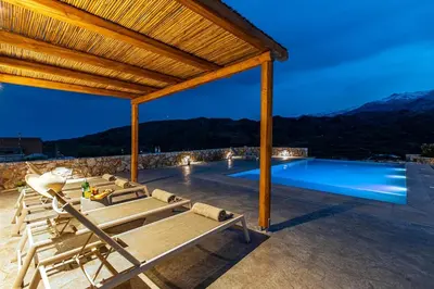a patio with chairs and a swimming pool at Villa Alargo Heated Pool in Katokhórion