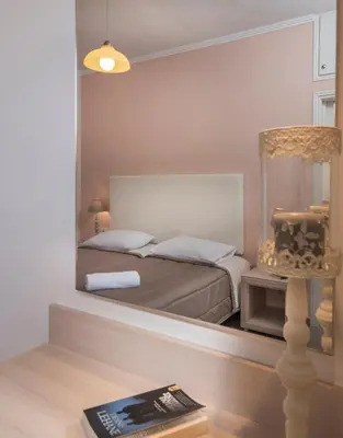 a reflection of a bedroom with a bed in a mirror at Mear Luxury Holiday Homes - Cretan Sunny Gems in Kountoura Selino