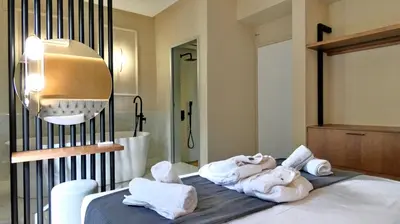 a room with towels on a bed with a bathroom at GoldenRoyalSuites in Stalos