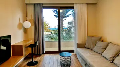 a living room with a couch and a large window at GoldenRoyalSuites in Stalos