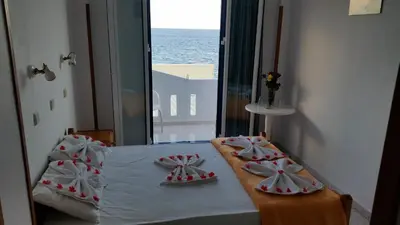 a room with a bed with a view of the ocean at Tarra in Agia Roumeli