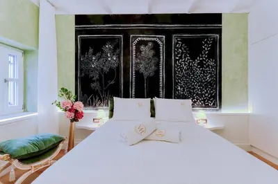 a bedroom with a white bed and a black and white wall at Madame Hortense Boutique Ηotel in Chania Town