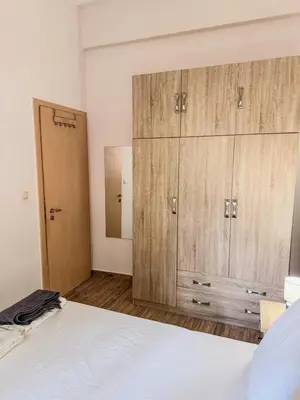 a bedroom with a bed and a large wooden cabinet at Mike's appartments in Chania Town