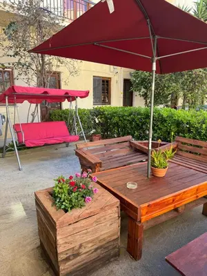 a picnic table with an umbrella and some flowers at Mike's appartments in Chania Town