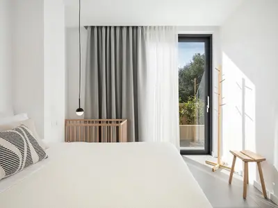 a white bedroom with a large bed and a window at Villa Melista in Kounoupidhianá