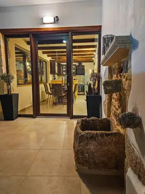 a living room with sliding glass doors and a table at Villa Cisternis in Stérnai