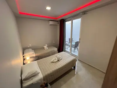 a hotel room with two beds and a balcony at Holiday Base in Stalos