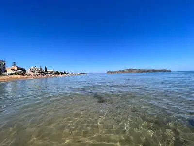 a body of water with a beach in the background at Holiday Base in Stalos