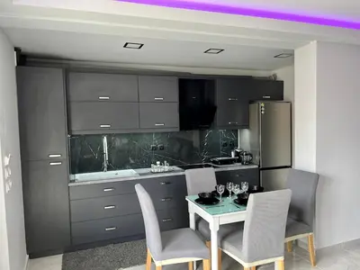 a kitchen with a table and chairs and a refrigerator at Holiday Base in Stalos