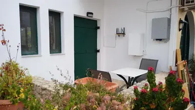 a white building with a green door and a table at Elysian Garden in Kalyves