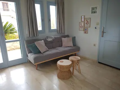 a living room with a couch and a table at Elysian Garden in Kalyves