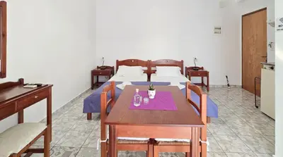a hotel room with two beds and a table and chairs at Inna Rooms in Fournádhos
